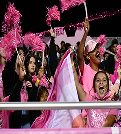 Students wearing pink waving pink pom poms